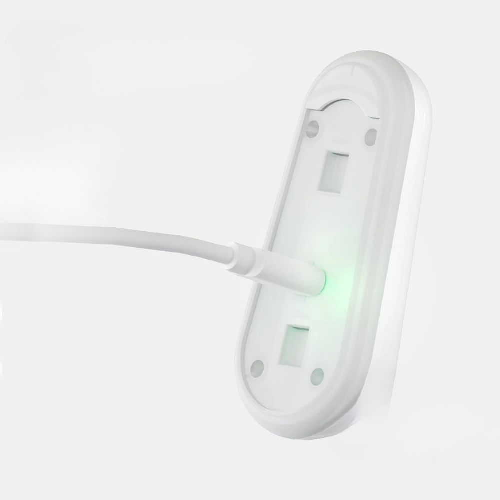 White wall-mounted electrical outlet with a green light on a white background
