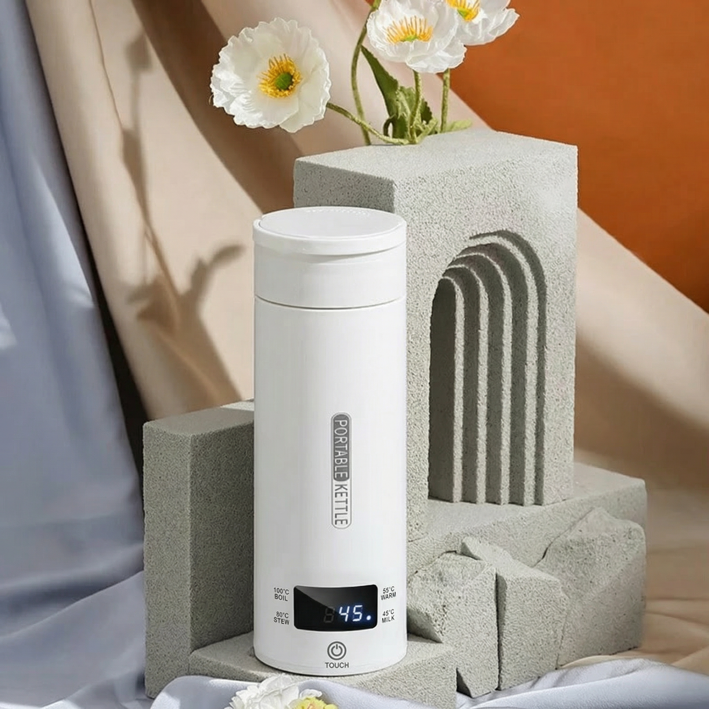 White portable kettle with digital display on a neutral background with flowers