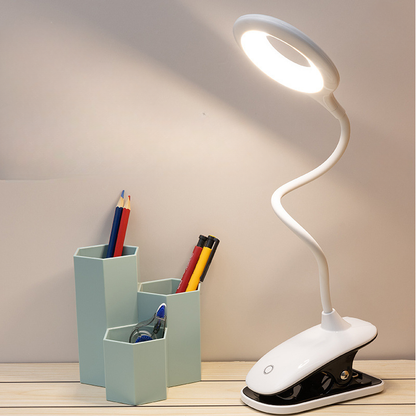 White LED desk lamp with flexible neck on a wooden surface next to a pen holder with stationery items.