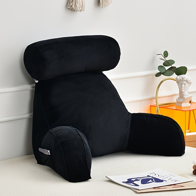 Black backrest pillow on a bed with a white wall and decorative items in the background