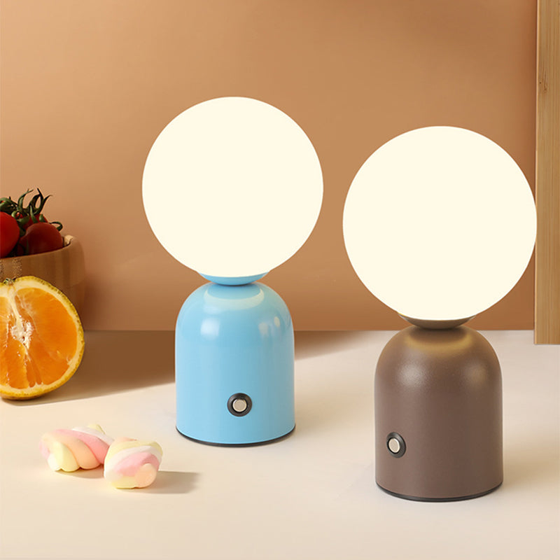 Two round table lamps with different colored bases on a neutral background