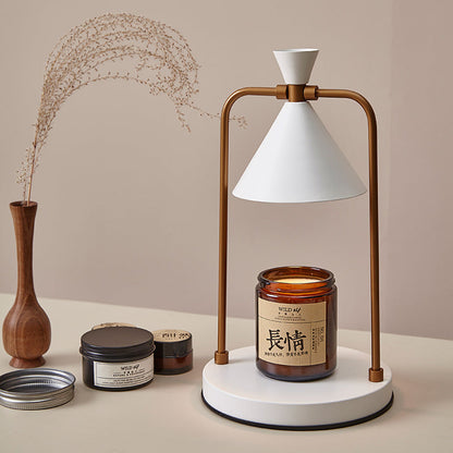 Decorative setup with a lamp, candles, and a vase on a beige surface.