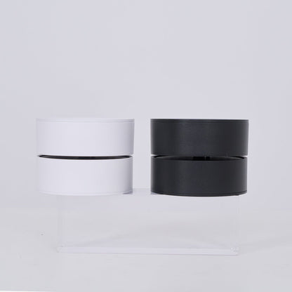 Two cylindrical lamp, one white and one black, on a light gray background.