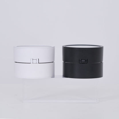 Two cylindrical lamp, one white and one black, on a light gray background.