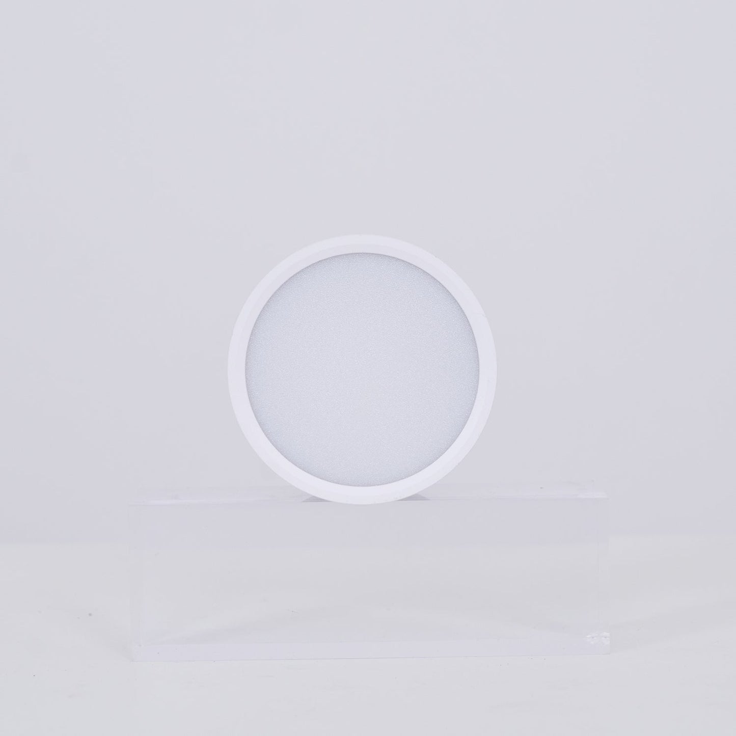 White circular lamp on a light gray background