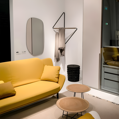 Modern living room with a yellow sofa, small tables, and decorative items.