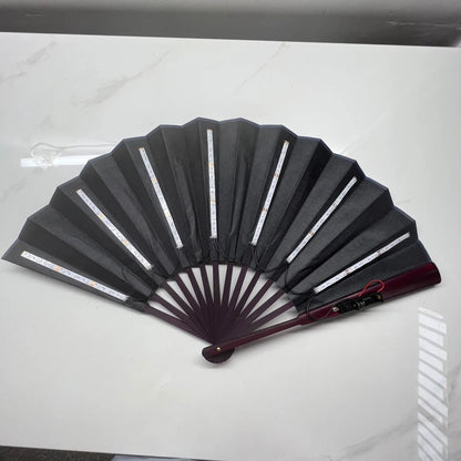 Black folding fan with red handle on a white background