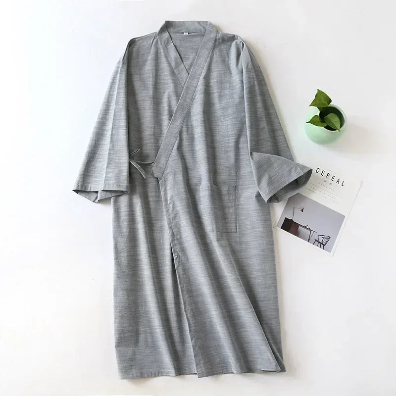 Gray robe on a white surface with a plant and magazine in the background