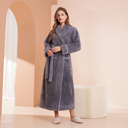 Woman wearing a gray robe in a room with a white ottoman and archway.