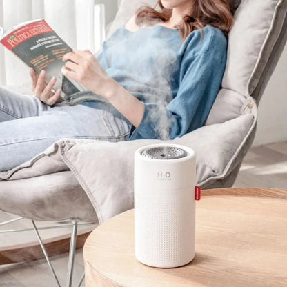 Person reading a book with a humidifier on a table in the foreground