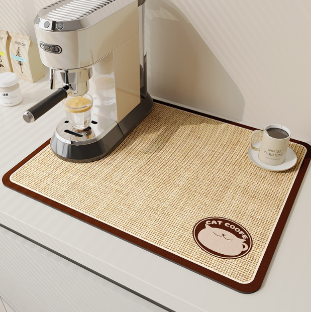 Coffee mat with a cat design next to an espresso machine on a kitchen counter.