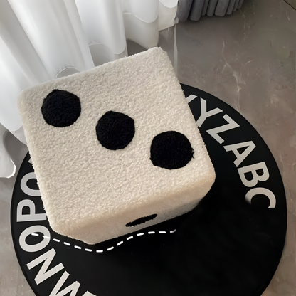 Square cushion with black circle design on a circular mat with alphabet print