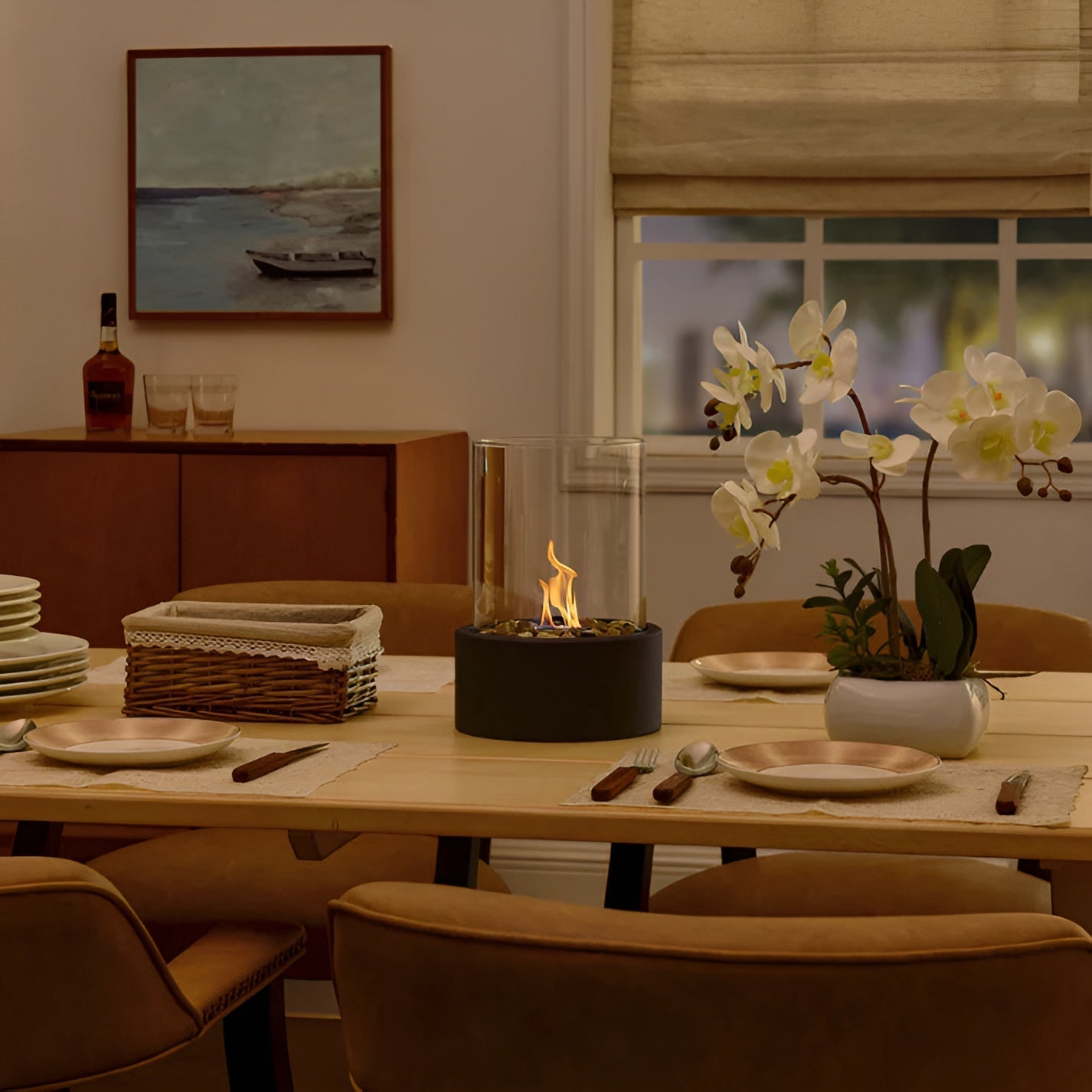 Dining room with a table set for a meal, featuring a fire pit and decorative elements.