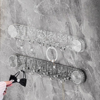 Wall-mounted jewelry organizer with various items on a marble wall.