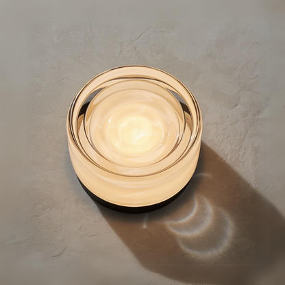 Round wall light fixture on a textured wall in the foreground