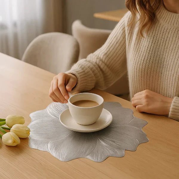 Person holding a cup of coffee on a wooden table with tulips