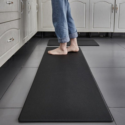 Person standing on a black anti-fatigue mat in a kitchen.