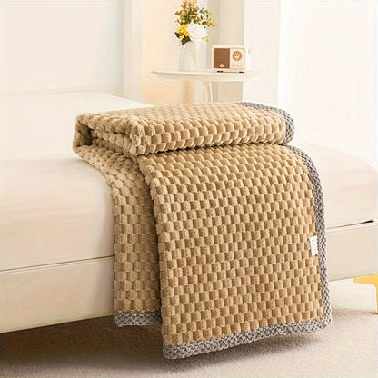 Beige quilt draped over a sofa in a living room setting