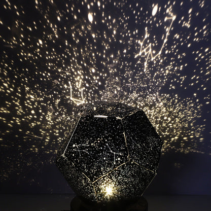 Star projector creating a night sky pattern on a dark wall