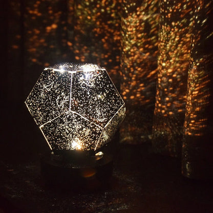 Decorative lamp with geometric design casting a pattern on a wall