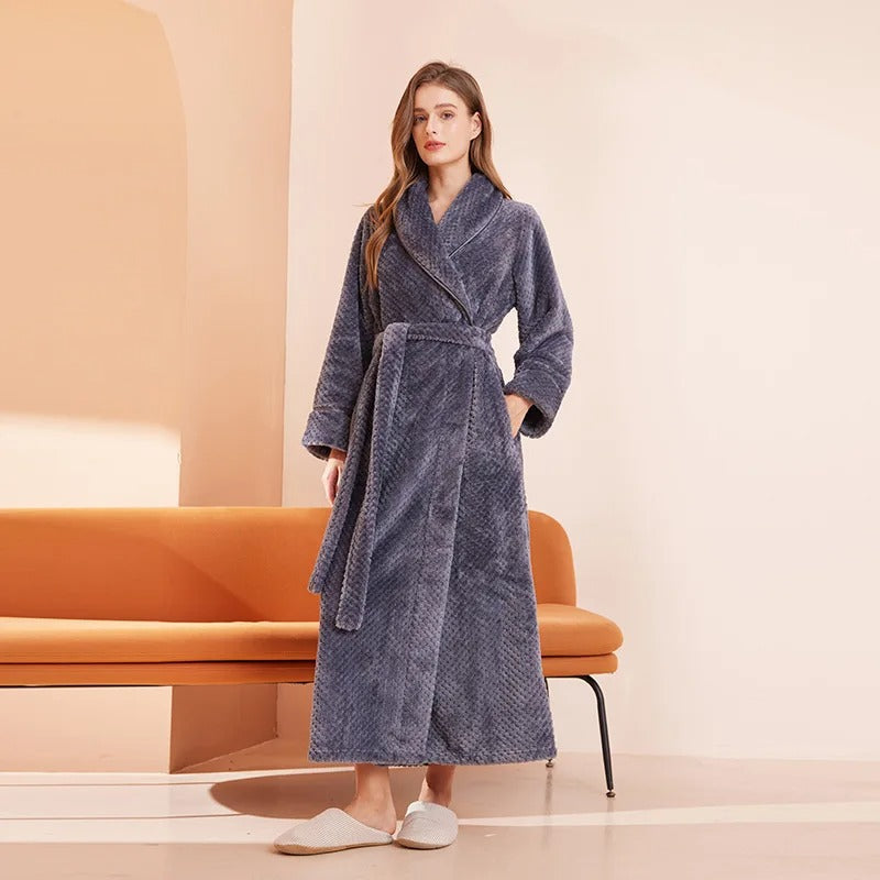 Woman wearing a blue robe standing in a room with an orange chair.