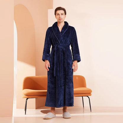 Man wearing a blue robe standing in a minimalistic room with an orange chair.