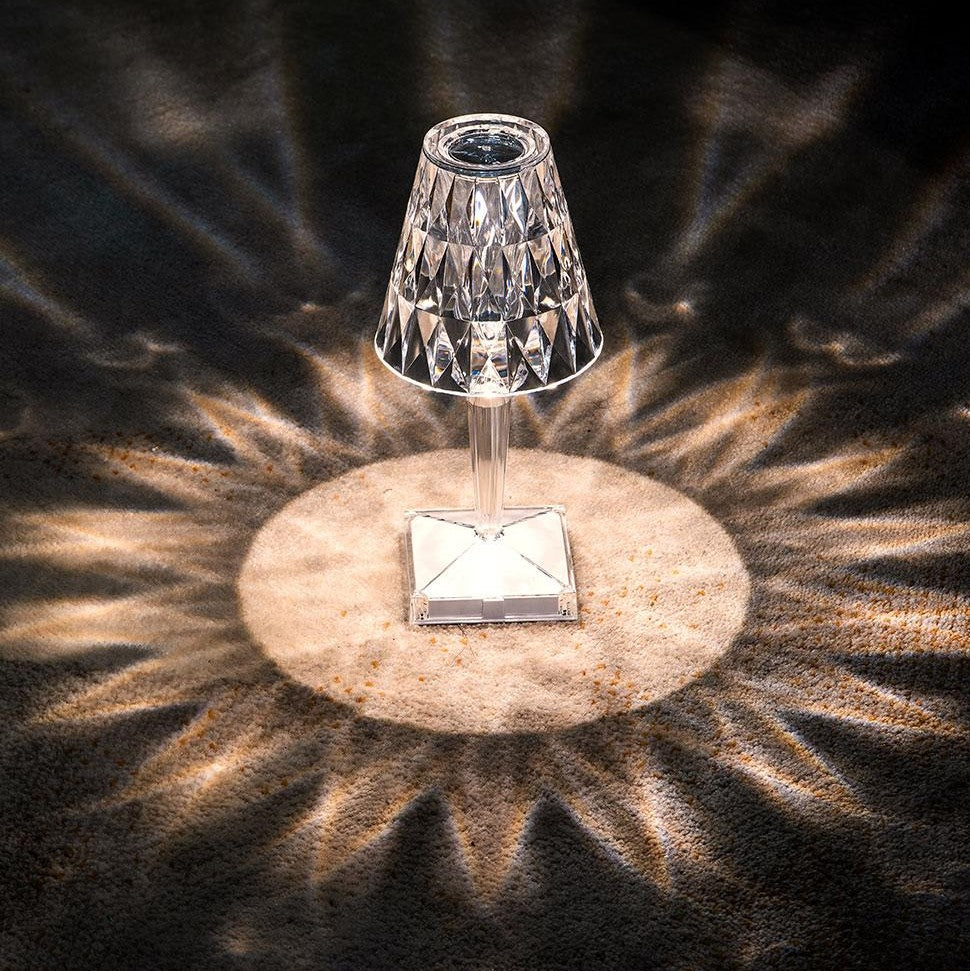 Solar-powered outdoor light with crystal-like design on a dark surface