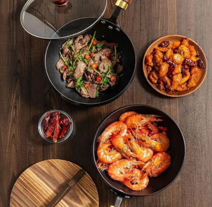 Assorted dishes including shrimp, stir-fried vegetables, and a bowl of fried food on a wooden table.